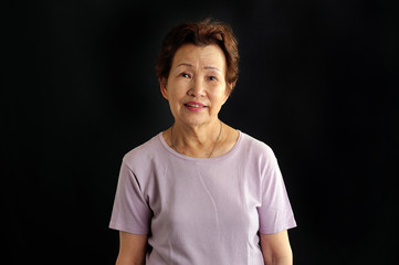 黒背景で撮影した笑顔の高齢者