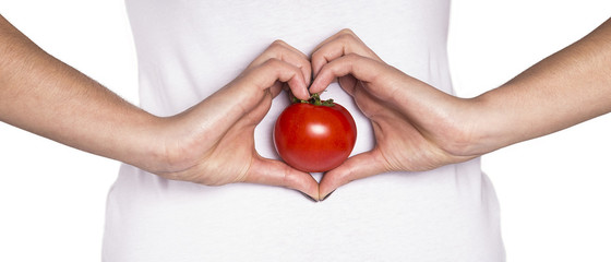 smiling woman with organic food showing heart shape with hands