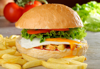 Big veggie burger with egg, fresh vegetables and french fries