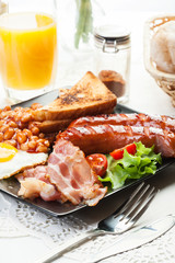 Full English breakfast with bacon, sausage, egg, baked beans and