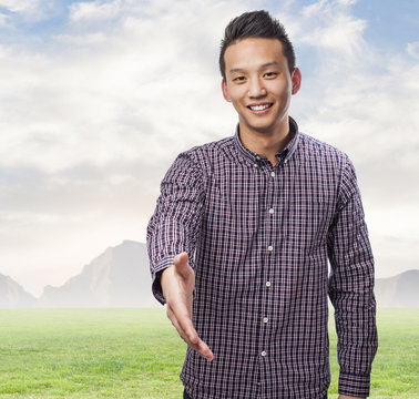 Portrait Of Young Asian Man Doing A Welcome Gesture