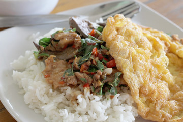 thai food. Fried basil leave with pork on rice  omelette