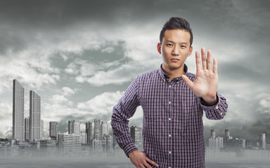 young asian man doing stop gesture with hand