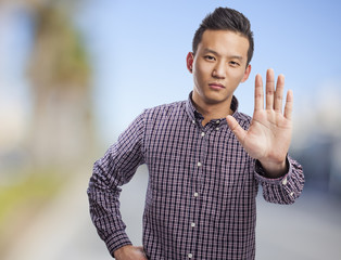 young asian man doing stop gesture with hand
