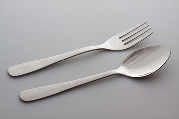 a silver fork with spoon isolated on gray background