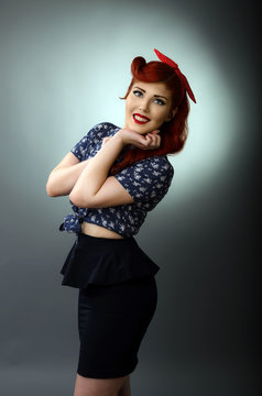 Portrait of a happy pin up girl isolated on gray background