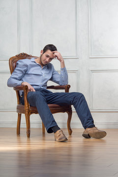 Young handsome guy in arm-chair