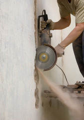 Мужчина разрезает стену