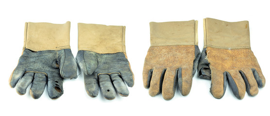 A dirty and well-worn pair of canvas and leather work gloves on