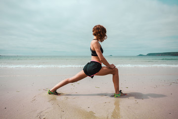 Young woman stretching on the beach