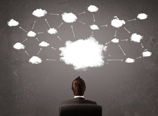 Businessman sitting with cloud technology above his head