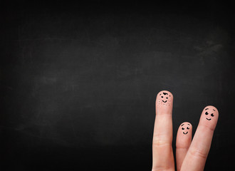 Happy smiley fingers looking at empty black chalboard