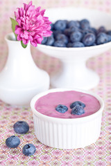 blueberry yogurt with a fresh berries in a cup on the table .