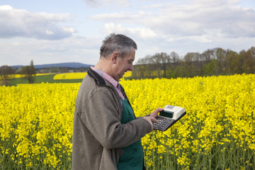 Farmer with calculation engine in the rape field