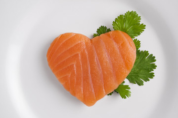 Heart shaped salmon on white plate