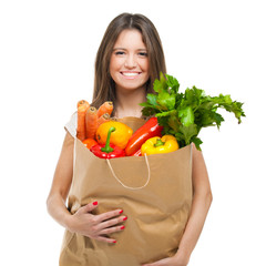 Young woman holding a bag full of vegetables