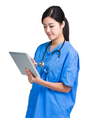 Asian female doctor look at tablet