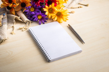 Notebook, diary, pen and flowers on the table