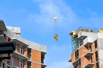 Crane lifting concrete mixer container on constructoin site
