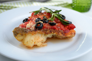 Baked cod under tomato sauce