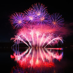 Colorful spectacular fireworks with reflections in the water