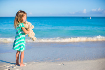 Adorable little girl with her bunny toy on tropical beach