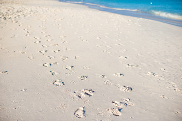 Human footprints on white sand of the Caribbean island
