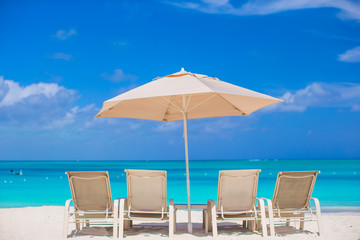 White umbrella and sunbeds at tropical beach