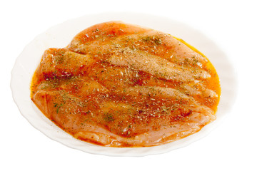 Raw marinated chicken breasts with spices isolated on white