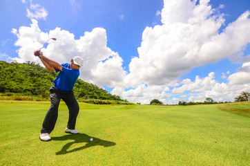 Golfer swinging his gear and hit the golf ball from tee to the f