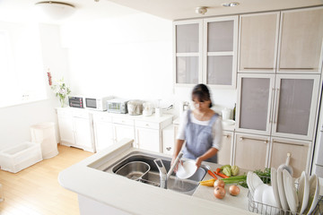 キッチンで家事をする女性 © kazoka303030