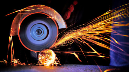 Worker cutting metal with grinder