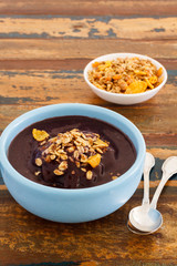 Brazilian dessert Acai in blue bowl with muesli and spoon