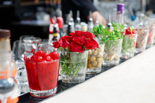 Cherries, herbs and flowers on bar counter