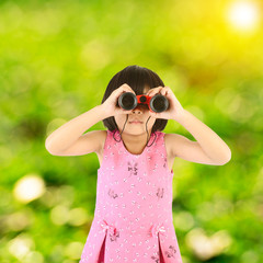 Girl with binoculars sun flare and green bokeh background