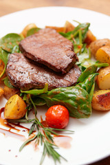 Steak with fried potatoes in plate