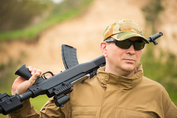Fototapeta premium Man in camouflage with a shotgun