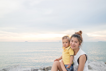 Fototapeta na wymiar Asian boy pose on the beach with his mother