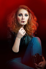 Beautiful young woman in a rock style sitting on the floor