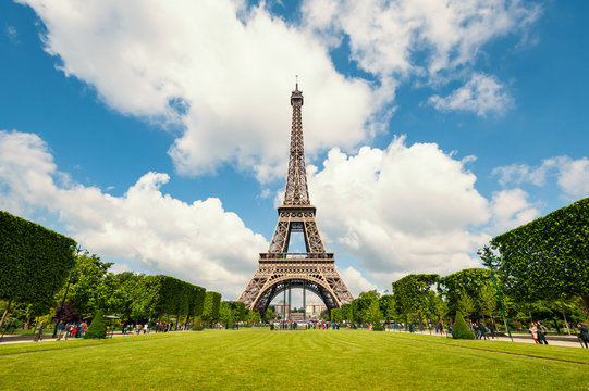 Eiffel Tower and gardens isolated against blue cloudy sky. Paris