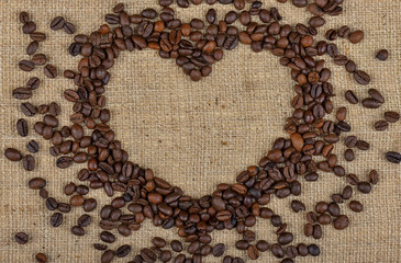 Heart from coffee beans on burlap background