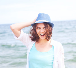 beautiful girl in a hat on a background of the sea, in soft focu