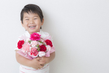 カーネーションの花束を持つ子供