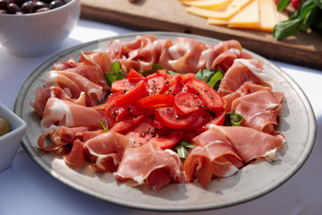 Platter with cured ham on table