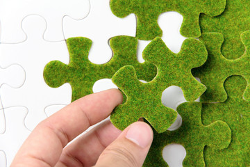 hand holding a green puzzle piece, green concept - Powered by Adobe