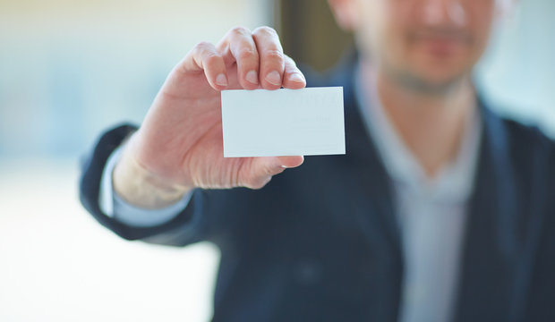 Man's hand showing business card