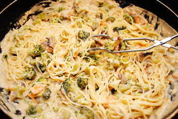 Pasta Cooking with Cream Sauce and Vegetables
