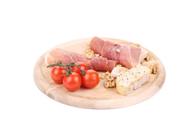 Prosciutto and tomatoes with bread on platter.