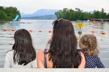 Fototapeta na wymiar Mother and girls contemplating a lake