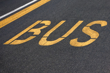 Bus written on asphalt - Travel by bus, concept image.